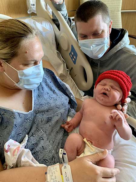 Jacklynn-Buttweiler Father and Mother wearing masks and holding newborn Baby